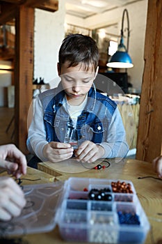 Child making bracelet at workshop