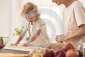 Child making cake with grandmother