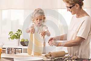 Child making cake with grandmother