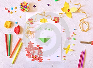 A child is making a card of a summer princess girl with flowers, paper craft, plasticine, beads, coloful clay and applique,  Craft