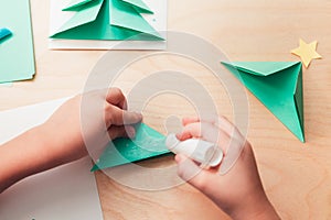 Child making Christmas card from paper. Step 5