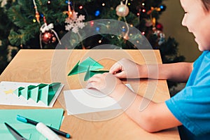 Child making Christmas card from paper. Step 5