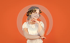 Child making hairstyle. little happy girl with curlers in hair. fabric mask under eyes for beauty. cute kid standing photo