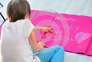 A child making Happy Monday Banner