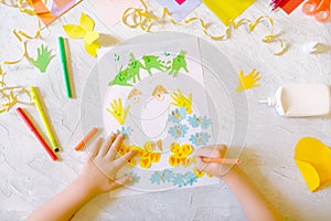 Child making homemade greeting card. little girl making card for mom with flowers from paper as gift for Mothers day, Birthday or