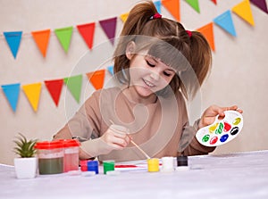 Child making homemade greeting card. Little girl paints heart on homemade greeting card as gift for Mother Day.