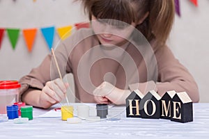 Child making homemade greeting card. Little girl paints heart on homemade greeting card as gift for Mother Day.