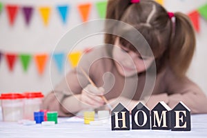 Child making homemade greeting card. Little girl paints heart on homemade greeting card as gift for Mother Day.