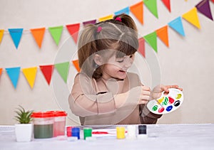 Child making homemade greeting card. Little girl paints heart on homemade greeting card as gift for Mother Day.