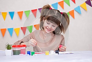 Child making homemade greeting card. Little girl paints heart on homemade greeting card as gift for Mother Day.