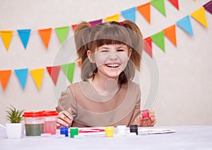 Child making homemade greeting card. Little girl paints heart on homemade greeting card as gift for Mother Day. Traditional play