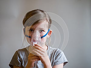 Child making inhalation with mask on his face. Asthma problems concept