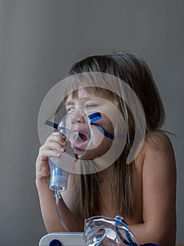 Child making inhalation with mask on his face. Asthma problems concept