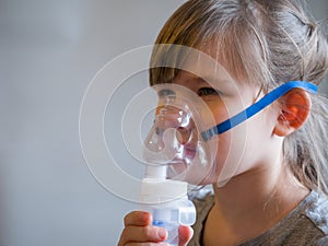 Child making inhalation with mask on his face. Asthma problems concept photo