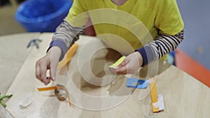 A child is making a paper craft on a table