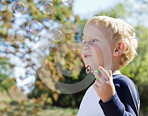 Child making soap bubbles outside