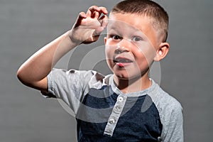 A child male model, missing teeth, looking at camera