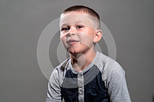 A child male model, missing teeth, looking at camera