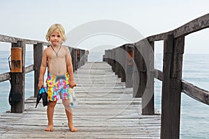 Child with mask, fins going to snorkel in tropical sea