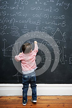 Child, math and blackboard with writing in classroom for knowledge, development and young genius in school. Kid, numbers