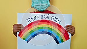 A child with medical mask and rainbow message in Castellano Spanish photo