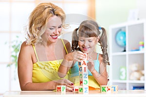 Child and mom playing wooden toys at home