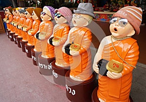 Child monk statue wear an eyeglasses. He's holding alms bowl