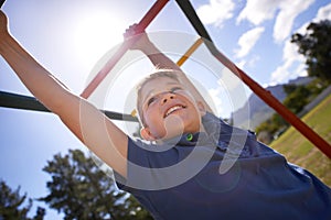 Child, monkey bars and energy on playground, smiling and obstacle course on outdoor adventure at park. Happy male person
