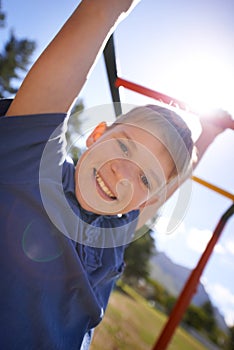 Child, monkey bars and smile in portrait, hanging game and obstacle course on outdoor adventure at park. Male person