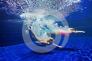 Child with mother dive in swimming pool