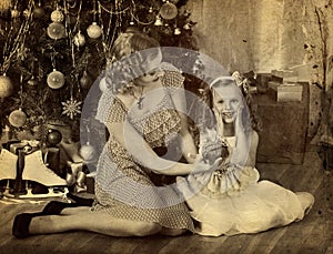 Child with mother and doll near Christmas tree.