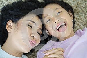 Child and mother lying together on the carpet