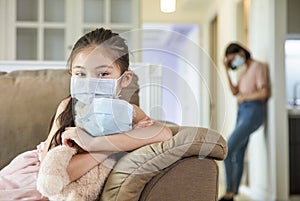 Child and mother in medical masks while coronavirus quarantined at home photo