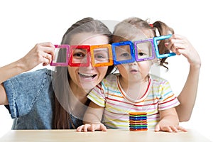 Child and mother playing with magnetic constructor