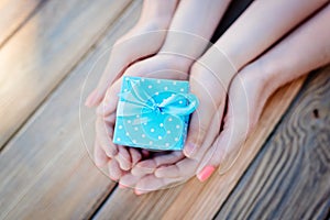 Child and mother`s hands holding a gift