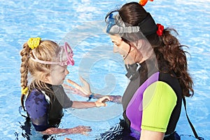 Child with mother in swimming pool .