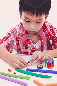 Child moulding whale modeling clay, on white background.