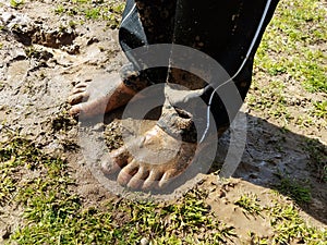 Child with muddy feet and mud and grass