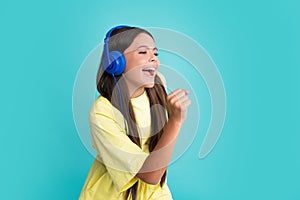 Child music concept. Teenager child girl dances in rhythm of melody, listens song in headphones. Child listening to