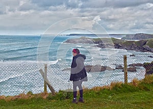 Child near the fenced cliffs in Newquay, UK photo