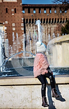 Child near Sforza Castle in Milan, Italy looking at fontain