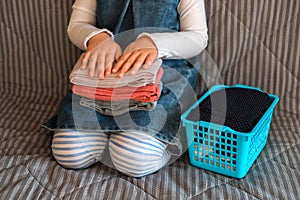 Child neatly folds a stack of clothes.