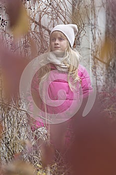 Child next to the wall with wild grapes