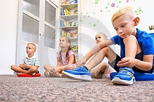 Child occupational therapy background. Elementary age children in group therapy. Pupils in class sitting on the floor.