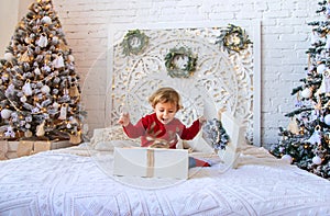 Child open Christmas gifts under the tree. Selective focus.