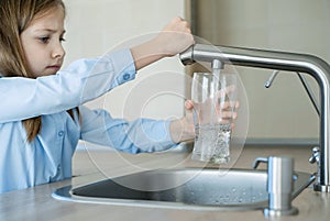 Child open water tap. Kitchen faucet. Glass of clean water. Pouring fresh drink. Hydration. Healthy lifestyle. Water quality check