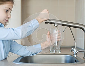 Child open water tap. Kitchen faucet. Glass of clean water. Pouring fresh drink. Hydration. Healthy lifestyle. Water quality check