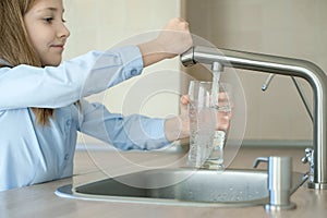 Child open water tap. Kitchen faucet. Glass of clean water. Pouring fresh drink. Hydration. Healthy lifestyle. Water quality check