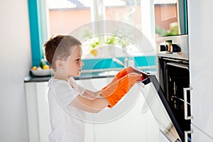 Child opening oven in kitchen.