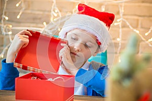 Child opening present from Santa Claus at home.